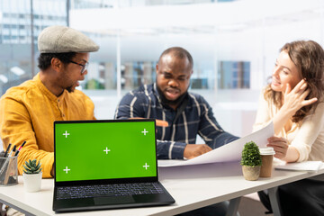 Female realtor reviewing architectural plans with clients next to green screen, securing a leasing contract with business partners looking to invest in real estate. Corporate strategy planning.