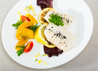 Dietary hake fillets steamed, served with boiled corn, greens and lemon. Recipe: hake 250g simmered in pan with water and olive oil for 10 minutes, season with salt and pepper