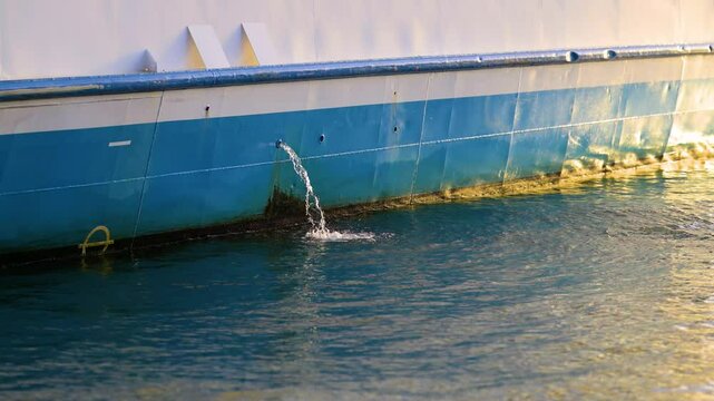 Bilge water being pumped out of a blue ship
