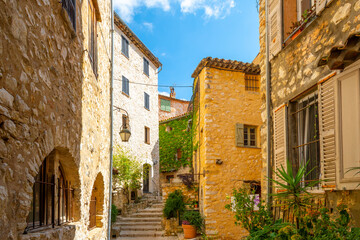 Colorful medieval stone buildings along the Grand Rue main street through the hilltop village of Tourrettes-sur-Loup, France, in the Alpes-Maritimes region of Southern France.	
