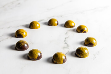 Cioccolatini assortiti di pasticceria in forme geometriche su marmo bianco come sfondo