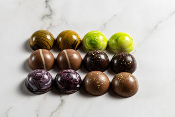 Cioccolatini assortiti di pasticceria in forme geometriche su marmo bianco come sfondo