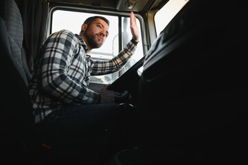 Side view of professional driver behind the wheel in truck's cabin