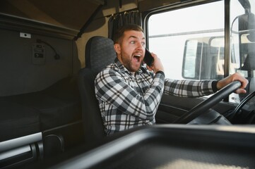 Portrait of handsome man professional truck driver sitting and driving big truck. He is dangerously...