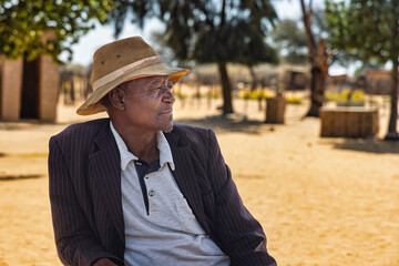 African village, Africa old man alone in front of the house, in the yard, solitude and loneliness at old age