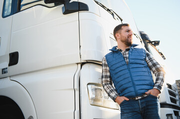 Happy confident male driver standing in front on his truck
