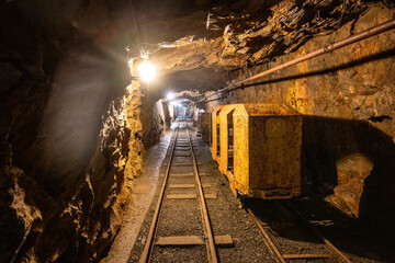 This narrow mine shaft in Jachymov, Czechia features a single rail track leading into the darkness....