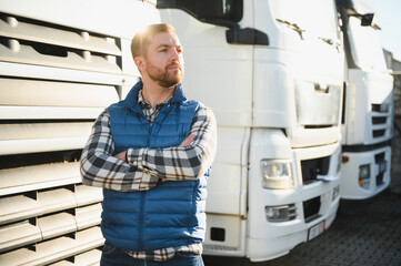 Portrait of young bearded trucker standing by his truck vehicle. Transportation service. Truck...