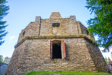 The remnants of a historic lime kiln stand near Kovarska, surrounded by lush greenery. The...