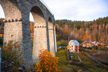 On a sunny autumn day, the impressive railway viaduct stands gracefully in Smrzovka, surrounded by...