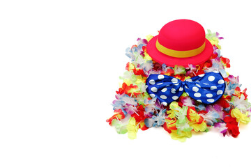 A colorful hat placed on a pile of Hawaiian necklaces and a clown bow tie. Perfect for carnival themes or playful decoration.