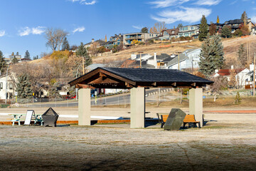 Community shelter at an outdoor park with fire pit and picnic tables in Calgary Alberta Canada.