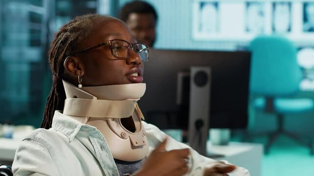 Wheelchair user with a fractured neck injury wearing cervical foam collar, talking to specialist about painkillers or advice for recovery. Young girl with spinal fracture at checkup. Camera A.