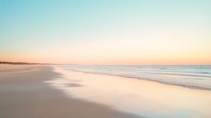 Fototapeta premium Serene stock photo of a tranquil sandy beach with calm ocean waves during a vibrant sunrise