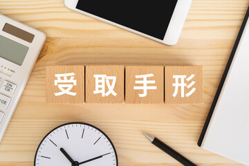 受取手形と書かれたブロック、電卓、スマホ
