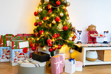 Background image of beautiful Christmas tree with gold and red accents and pile of presents in cozy home interior.