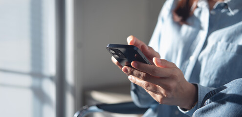 Woman using mobile phone at home. Casual business woman surfing the internet on smartphone during...