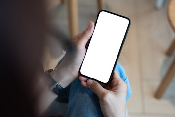 Cell phone mockup blank white screen. Woman hand holding mobile phone at coffee shop. Female hipster using smartphone, blank whire screen template for product advertising, mobile app design