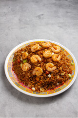 fried rice topped with shrimp, mixed with small pieces of meat.