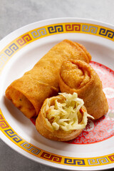 three spring rolls on a Chinese plate
