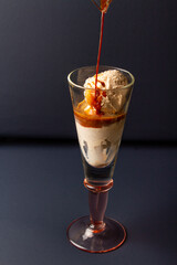serving an affogato coffee in a tall glass cup on a dark blue background