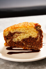 Marble piece of cake on plate with chocolate sirope for decoration