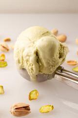 ice cream scoop of pistachio melting, and pistachio kernels, white background