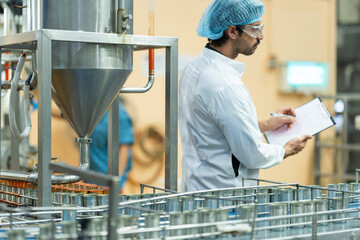 Industrial technician conducting quality checks on canned food in a manufacturing facility Emphasis...
