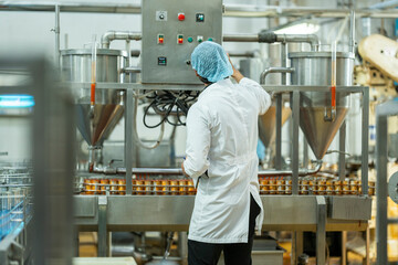 Industrial technician conducting quality checks on canned food in a manufacturing facility Emphasis...