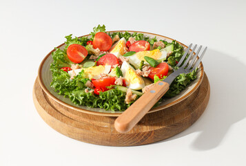 Ready salad with tuna on a wooden board.
