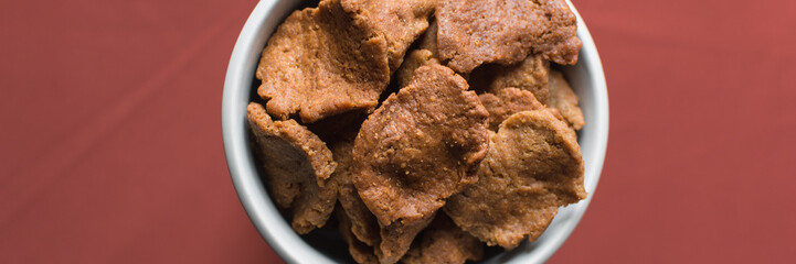 Overhead view of kuli-kuli in a white bowl, top view of nigerian groundnut cakes in a bowl