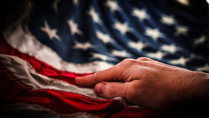 hand resting on United States flag american red white blue stripes and stars patriotic abstract honor reverence elegant abstract macro close-up background