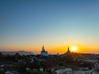Fototapeta premium Aerial view beautiful golden pavilion at Wat Phachonkeaw at sunrise..5 sitting buddha statues of Phachonkeaw on Khao Kho hill the beautiful landmark .and famous in Phetchabun Thailand.