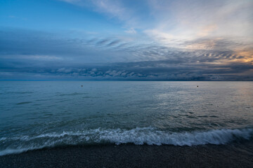 An incoming wave on the Black Sea coast against the sunset sky, Sochi, Krasnodar Territory, Russia