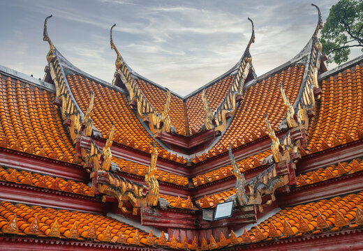 Bangkok, Thailand - March 20, 2024: Low angle view of red tile roof with decorations on the shrine of Wat Pho
