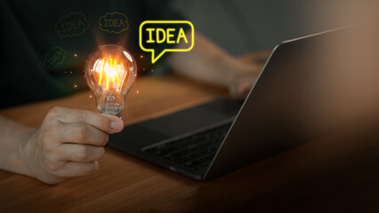 Male hand holding a glowing light bulb and 