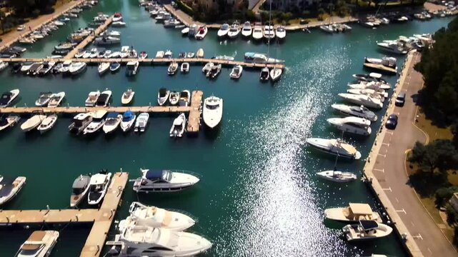 Experience the stunning marina of Santa Ponsa in Mallorca with boats docked peacefully and vibrant blue waters. The beautiful coastal scenery is complemented by clear skies and lush surroundings.