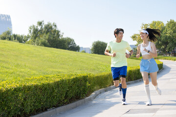 Happy young couple jogging outdoors