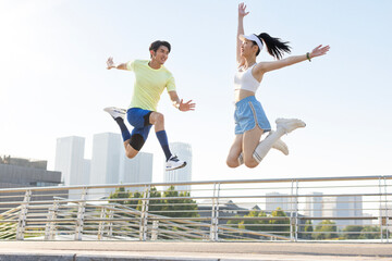 Happy young couple jumping in a park
