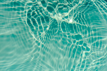 Blue water with ripples on the surface. Defocus blurred transparent blue colored clear calm water surface texture with splashes and bubbles. Water waves with shining pattern texture background.