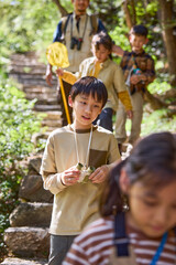 Happy teacher and kids hiking in the mountains