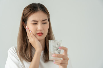 Asian woman feel sensitive teeth after drinking cold, female suffer tooth, decay problems, dental care, tooth extraction, decay problem, bad breath, Gingival Recession, Oral Hygiene instruction.