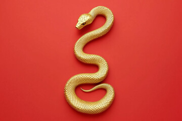 Obraz premium Gold snake isolated on a red background