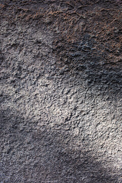 Textured brown wall with dappled light