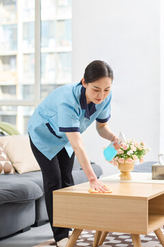 Female cleaner tidying up the apartment