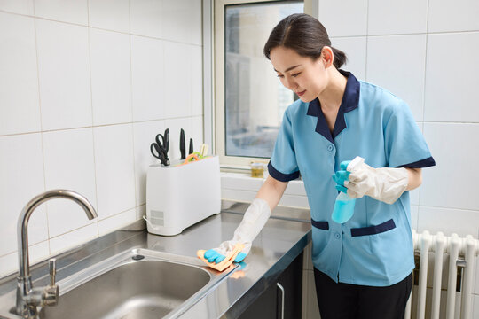 Cleaner tidying up the kitchen