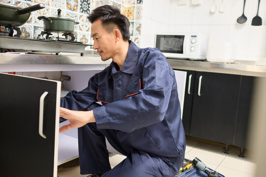 Handyman repairing the kitchen cabinet