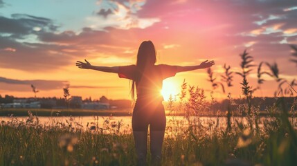 Silhouette of a woman with arms outstretched at sunset, representing freedom, peace, and optimism.