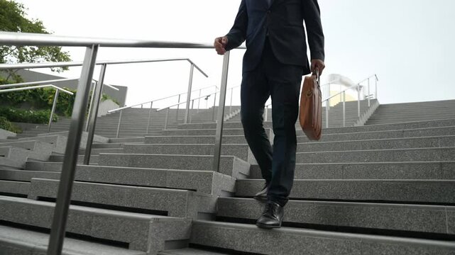 Closeup of skilled manager walking down stair with a bag and return to home. Closeup of project manager leg getting fired and walk to dormitory. Investor with untidy suit. Focus on leg. Exultant.