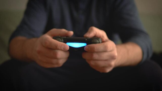 Guy with Controller Playing Videogames, Third Persons View, Focus on Hands and Gamepad